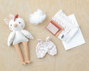 Stuffed Claire chicken toy with outfit and accessories on a wooden surface