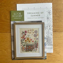 Dreaming of Summer Cross Stitch chart and pattern cover on wooden surface.
