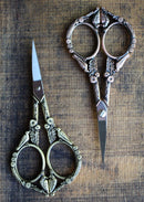 Feathered Friends Scissors in Antique Finish on wooden surface