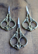 Feathered Friends Scissors in Antique Gold Finish on wooden surface