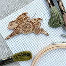 Leaping Hare Needle Minder on white aida cloth with embroidery floss.