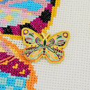 Mandala Butterfly Enamel Needle Minder on matching cross-stitch design.