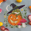 Pumpkin Toad Cross Stitched design of a frog with a witch hat and pumpkin.