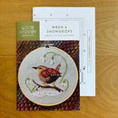 Wren & Snowdrops Cross Stitch chart and pattern cover with wren design on a wooden surface