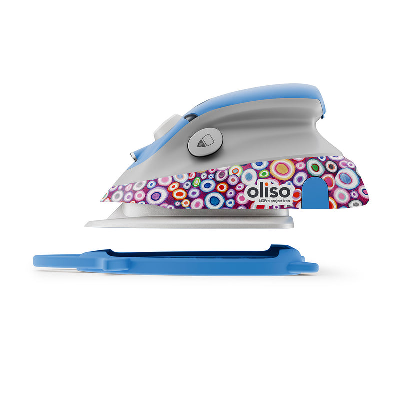 Oliso Mini Project Iron With Solemate Kaffe Fassett showing side of iron above solemate trivet 