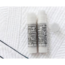 Two white tubes with black text of Apliquick Fabric Glue on a textured white surface.
