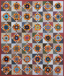Quilt with geometric pattern featuring various colors with red border from Bonnie Hunter's Scrap-Savvy Quilting
