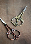 Butterfly Scissors in Antique Finish on wooden surface.