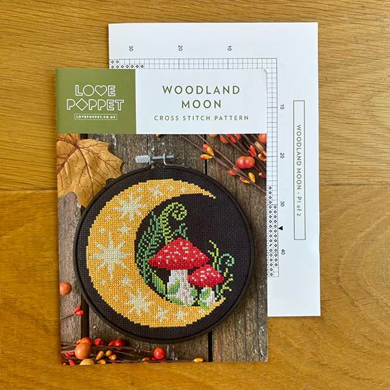 Woodland Moon printed chart and pattern cover on wooden surface