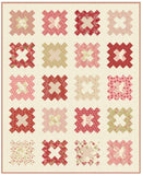 Dear One Quilt with a pattern of red, pink, and beige squares on a cream background