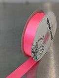 Roll of pink ribbon with a decorative label on a gray background. Double-Face Satin Ribbon 22mm (.875") Wide