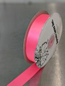 Roll of pink ribbon with a decorative label on a gray background. Double-Face Satin Ribbon 22mm (.875") Wide