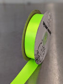 Spool of green ribbon with a label on a shiny urface. Double-Face Satin Ribbon 22mm (.875") Wide