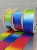Three rolls of Double-Face Satin Ribbon in rainbow colors, showing a smooth color-shifting gradient effect.
