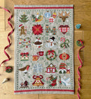 Feeling Festive Advent Cross-stitch finished design on wooden surface.