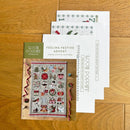 Feeling Festive Advent Cross stitch chart and pattern cover on a wooden surface