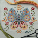 Floral Butterfly Cross Stitch with scissors and floss.