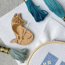 Fox Needle Minder on white aida cloth with embroidery floss.