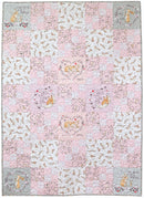 Guess How Much I Love You Baby/Child Quilt Kit in pinks shows a square quilted patchwork blanket featuring a whimsical bunny theme. The design consists of multiple pastel pink and white patterned squares with illustrations of bunnies, flowers, hearts, and text such as 'I LOVE YOU' and 'IT'S TIME FOR SNUGGLES'.
