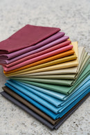 Laundry Basket Quilts Century Solids Fat Quarter Bundle laid on table