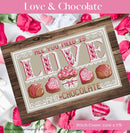 Love and Chocolate Cross Stitch Pattern is a cross-stitched design with 'All you need is love and chocolate' text on a wooden surface, surrounded by pink roses and chocolate candies.