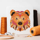 Mandala Bear Cross Stitch design on table with thread, hoop, and scissors.