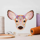 Mandala Deer Cross Stitch Pattern design stitched out and on table top surrounded by thread, scissors, and a hoop.