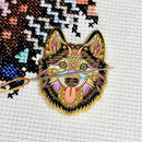 Mandala Husky Enamel Needle Minder on matching cross-stitch design.