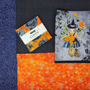 Neighborhood Views Quilt Kit fabrics in blues, blacks, and oranges with panel and charm square pack.