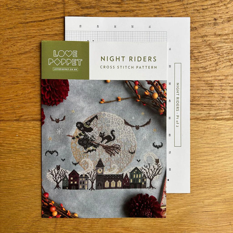 Cross stitch pattern chart and cover titled 'Night Riders' by Love Poppet on a wooden surface.