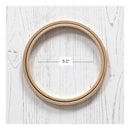 Wooden embroidery hoops on a white wooden surface with a measurement label indicating 5.1 inches.