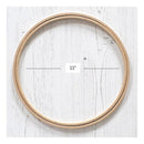 A wooden embroidery hoop shown on a white wood-textured background, with measurement lines and a small label indicating a 11-inch diameter.