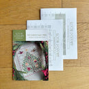 Oh Christmas Tree Cross Stitch Pattern with a Christmas tree design on a wooden surface