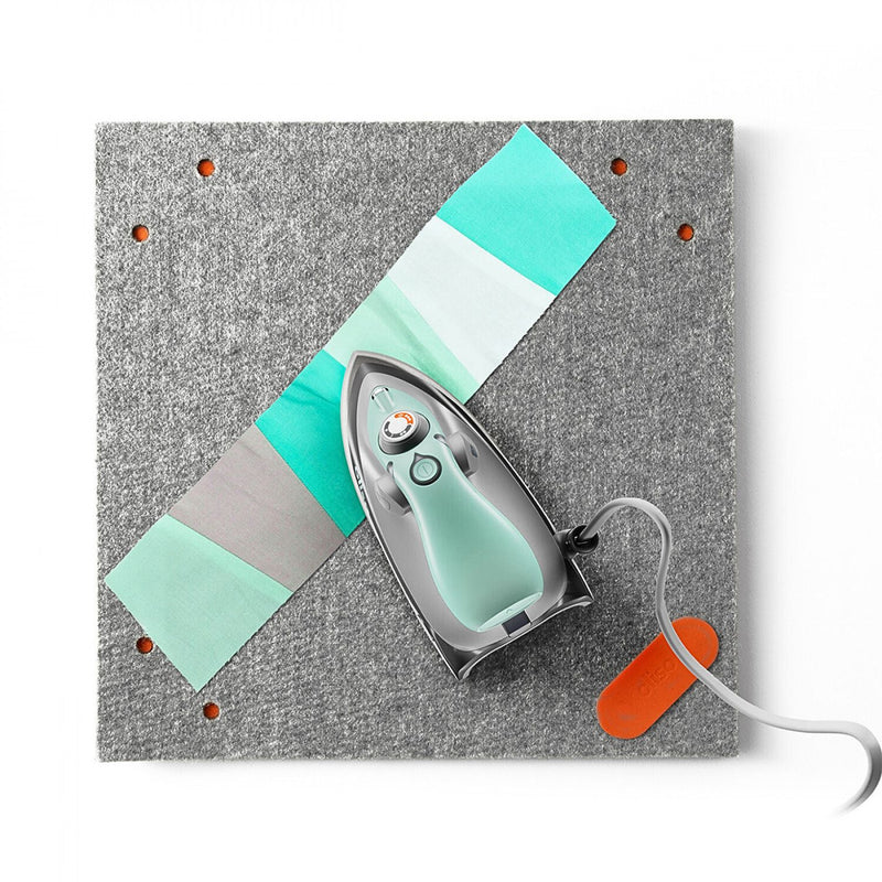 Oliso Mini Iron With Trivet Aqua Color Sitting on Fabric   M3PRO-AQUA