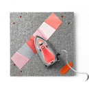 Oliso Mini Iron With Trivet Coral Color Sitting on Fabric M3PRO-CORAL