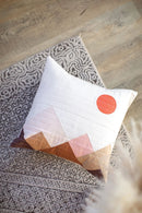 Pattern in "Quilts in Modern Color" shows decorative pillow with geometric mountain pattern on a textured rug.