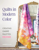 Book cover of "Quilts in Modern Color" with a colorful quilt displayed in front of a mirror.