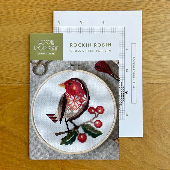 Rockin Robin Cross Stitch Pattern chart and pattern cover on wooden surface.