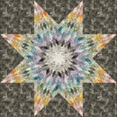Stellar Free PDF Quilt Pattern shows a Colorful star-shaped quilt on a dark geometric patterned background.