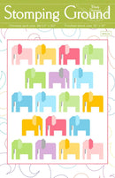 Colorful elephant pattern on a quilt design with 'Stomping Ground' branding.