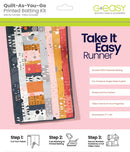 Take it Easy Table Runner Quilt-as-you-go printed batting packaging with colorful fabric strips on a pink background