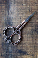 Victorian Scrollwork Scissors in Antique Copper finish on wooden surface