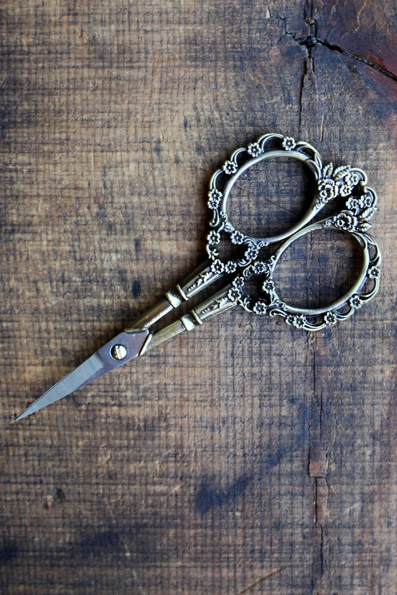 Victorian Scrollwork Scissors in Antique gold finish on wooden surface