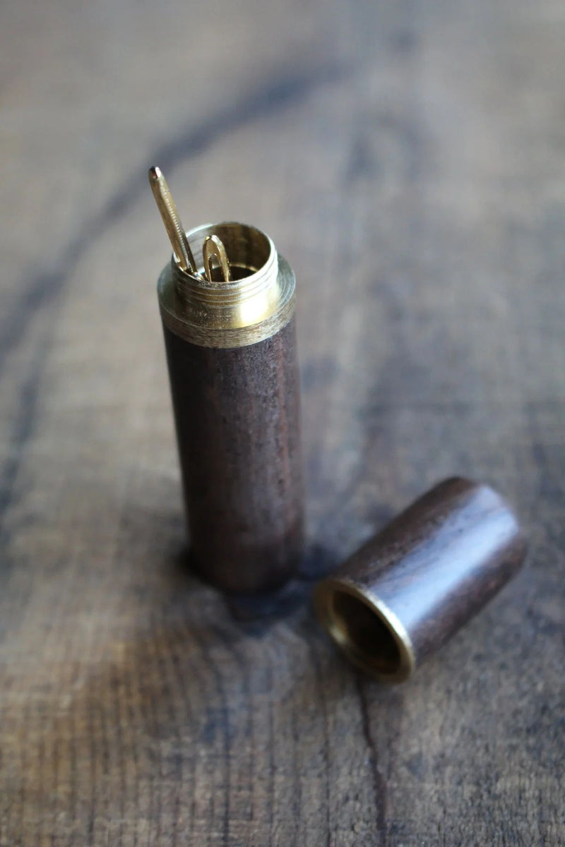 Ebony Wooden Needle Case with Tapestry Needles on wooden surface.