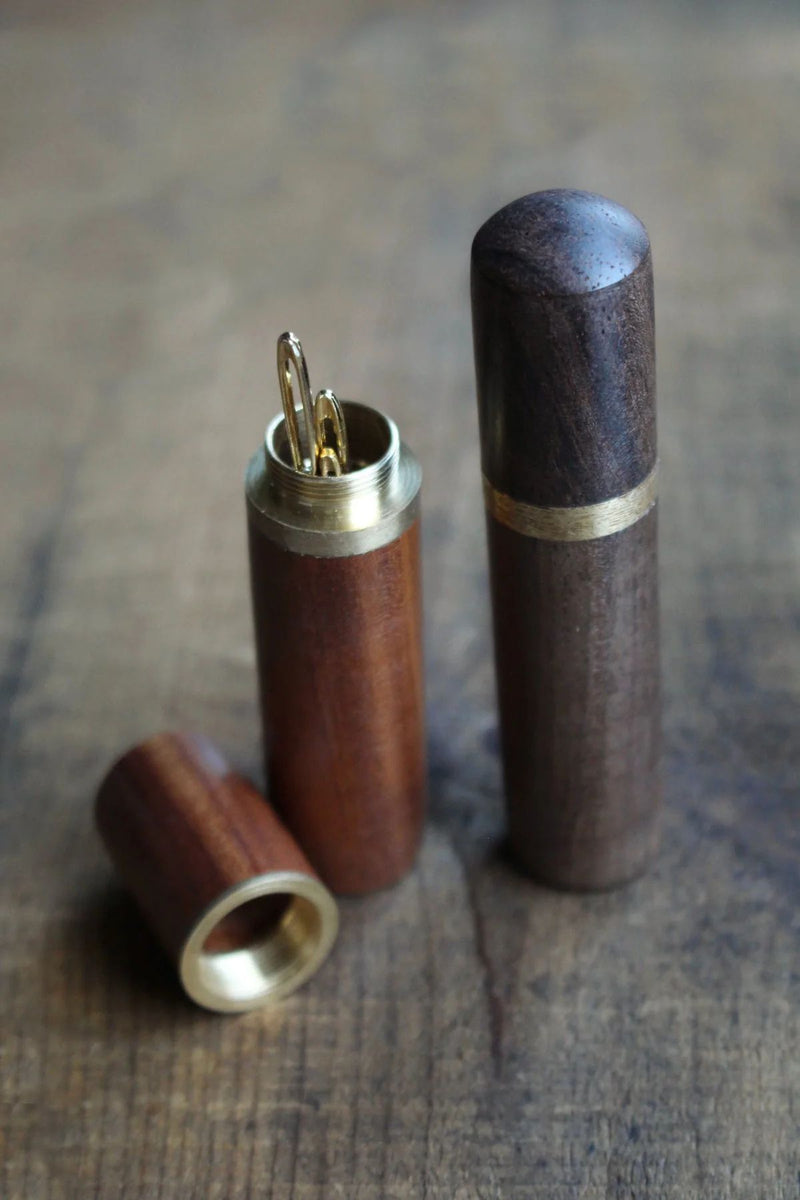 Wooden Needle Cases with Tapestry Needles on wooden surface.