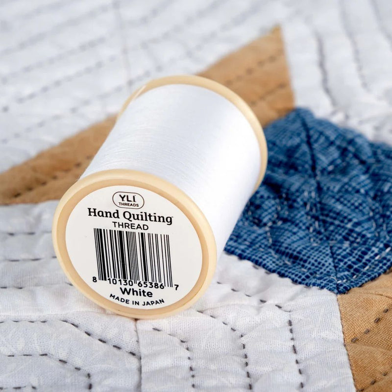 YLI Hand Quilting Thread 40 wt  3-ply 457 m (500 yd.) spool - White WHT showing bottom of spool